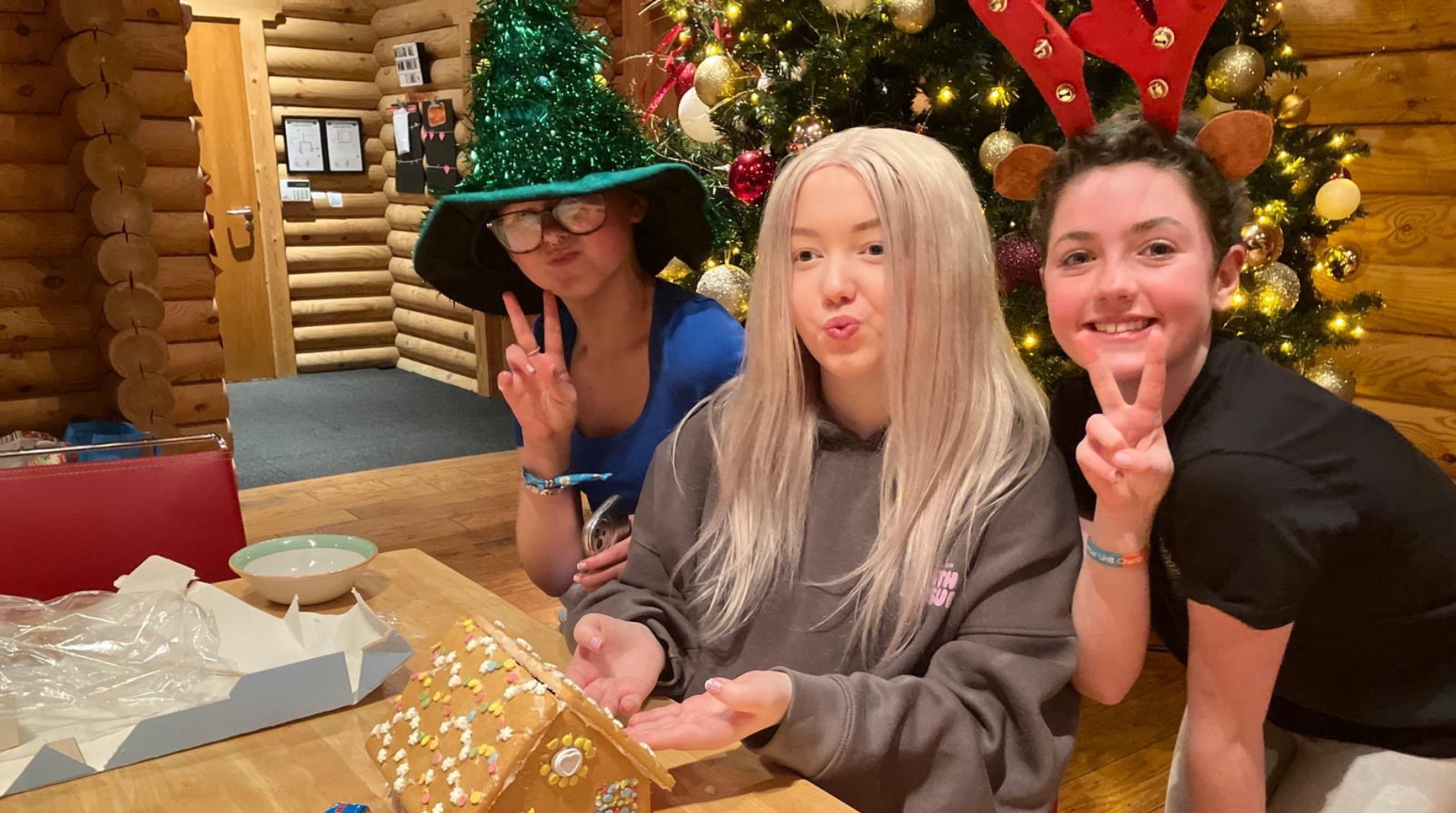 Keira and two friends posing with Christmas props in Narnia during a residential